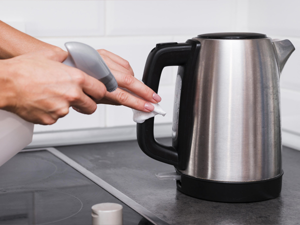 Hotel staff checking and descaling electric kettle for guest safety.jpg